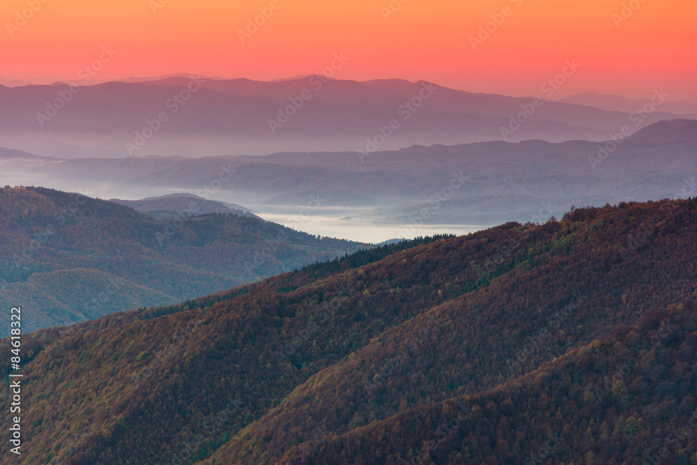 Beautiful landscape at dawn. Layers of mountain in pink light.