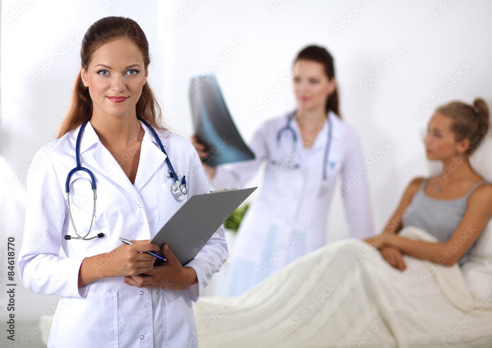 Smiling female doctor with a folder in uniform standing at Smiling female doctor with a folder in uniform standing at