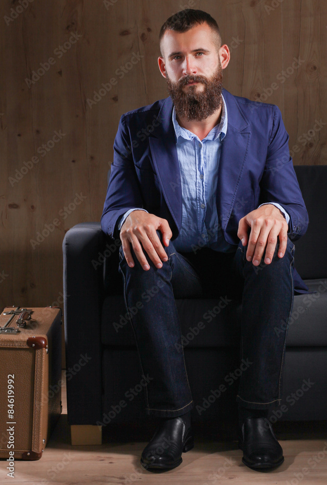 Businessman sitting the sofa in office lobby, isolated on dark Businessman sitting the sofa in office lobby, isolated on dark