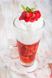 Strawberries in jelly topped with whipped cream
