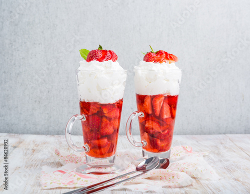 Strawberries in jelly topped with whipped cream