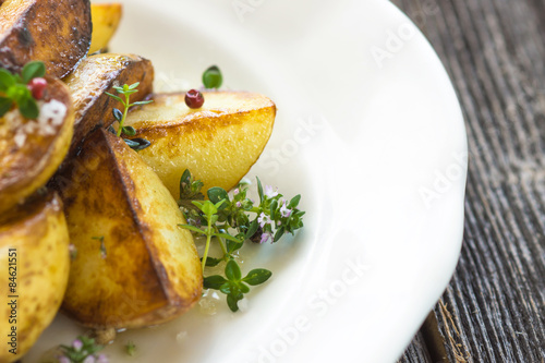 Baked new potatoes with herbs on a wooden background photo