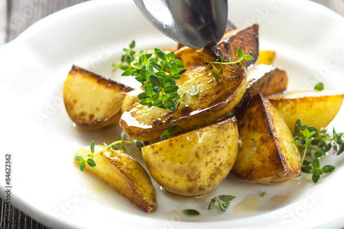 Baked new potatoes with herbs on a wooden background photo