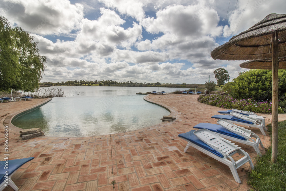 View of a beautiful swimming pool with a cloudy sky in a relaxation resort located in the Alentejo region, Portugal.