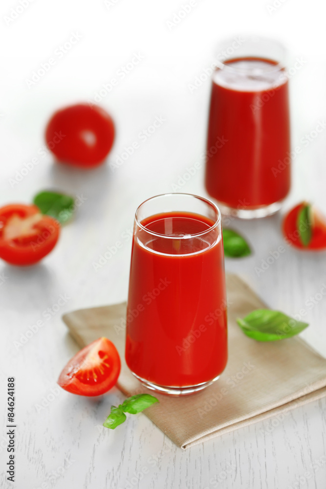 Tomato juice and fresh tomatoes on wooden table close-up Tomato juice and fresh tomatoes on wooden table close-up