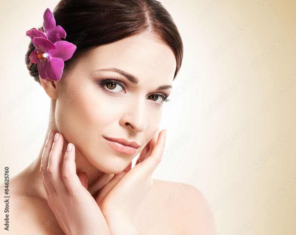 Beautiful face of a young and healthy girl with an orchid flower Beautiful face of a young and healthy girl with an orchid flower