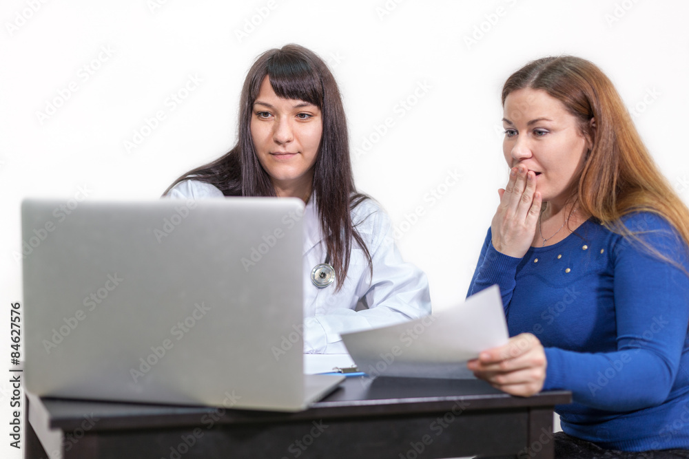 Young woman with fear looking in the monitor of the doctor Young woman with fear looking in the monitor of the doctor