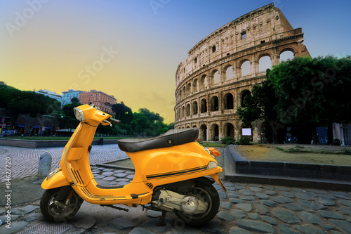 Yellow vintage scooter on the background of Coliseum #84627720