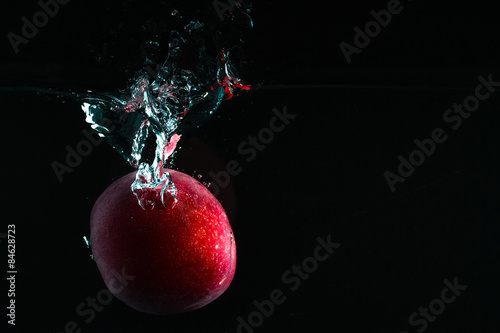 Splash photography: peach fruit on dark background