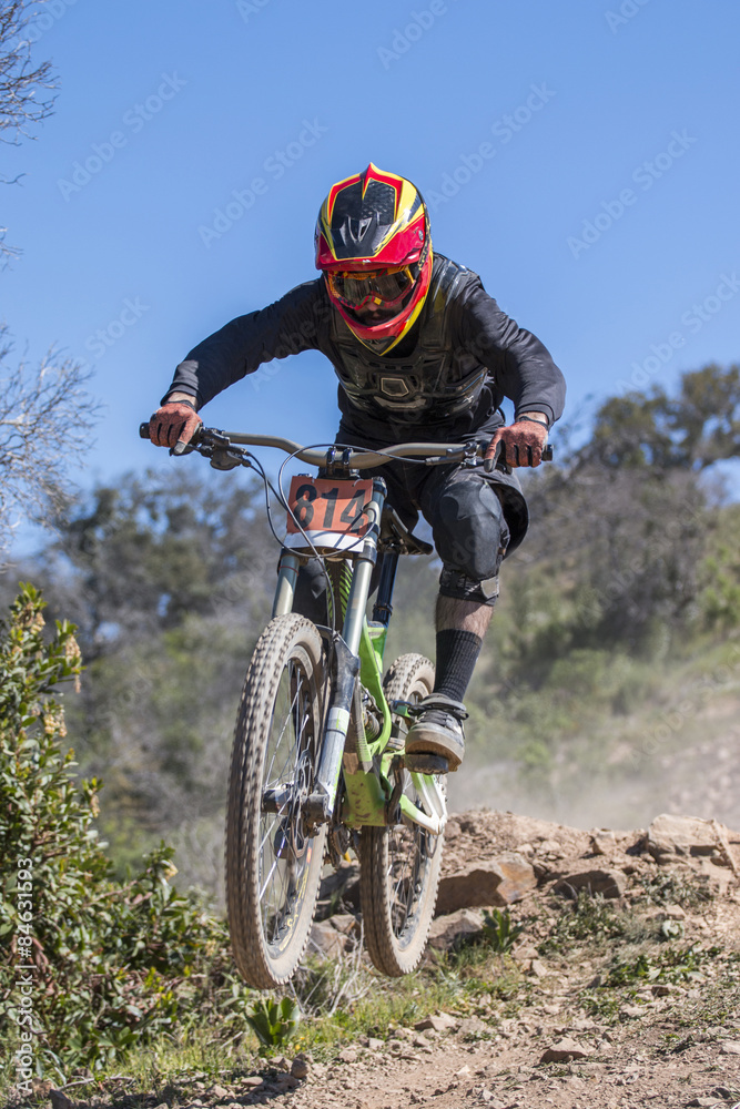 Downhill competition, Biker jumps fast in the countryside. Downhill competition, Biker jumps fast in the countryside.
