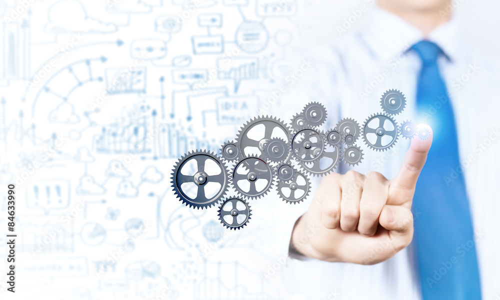 Businessman activating gears mechanism Businessman activating gears mechanism