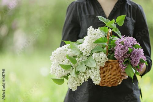 female teen girl hold basket full of lilac flowers