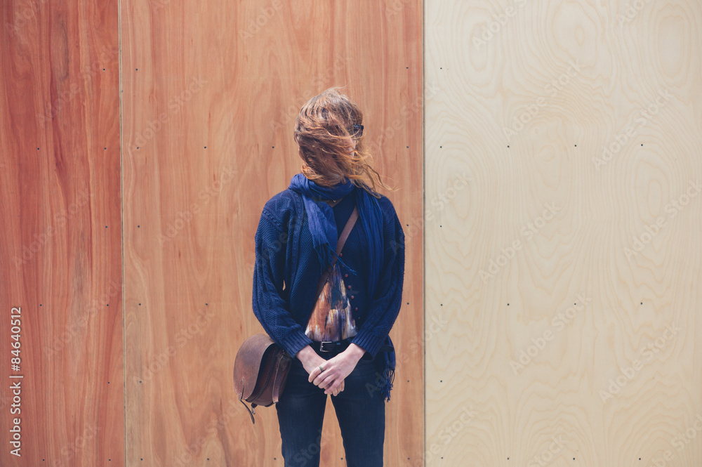 Young woman standing by two colored wooden wall Young woman standing by two colored wooden wall