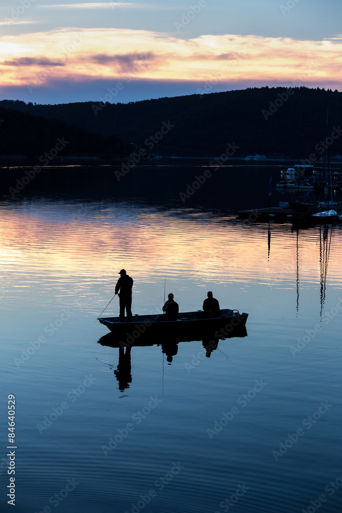 small fishermen ship on a sundown lake