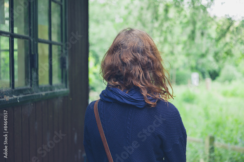 Young woman by cabin in the woods