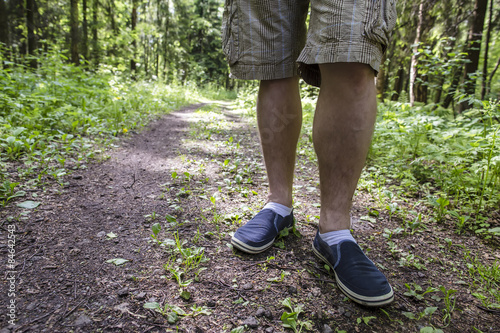 a man standing on the footpath after a long walk in the woods