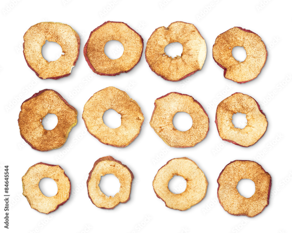 Dried apple rings sprinkled with cinnamon on white background.