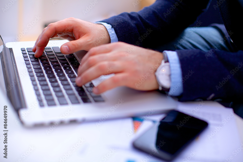 Businessman sitting at table with laptop and documents Businessman sitting at table with laptop and documents