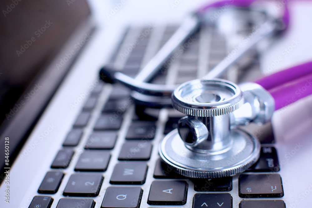 Violet stethoscope on a laptop computer Violet stethoscope on a laptop computer