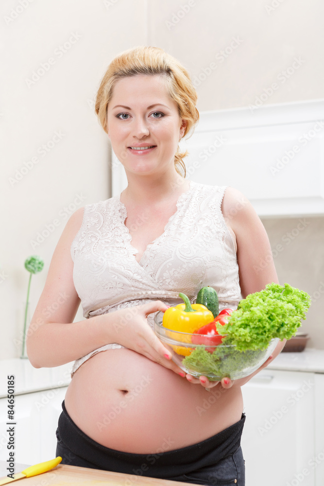 Pregnant woman standing in the kitchen Pregnant woman standing in the kitchen
