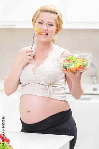 Pregnant woman eating tasty vegetable salad