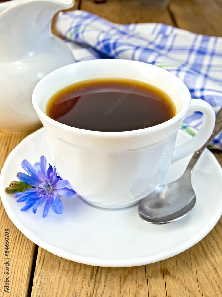 Chicory drink in white cup with spoon and milkman on board Chicory drink in white cup with spoon and milkman on board