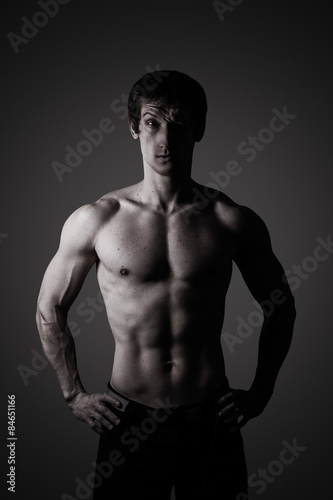Studio portrait of a sporty young man in low key © Belyaevskiy
