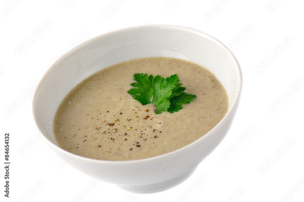 Mushroom cream soup in white bowl garnished with grated pepper and parsley leaf. Isolated Mushroom cream soup in white bowl garnished with grated pepper and parsley leaf. Isolated