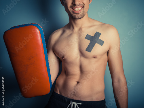 Athletic young man with martial arts pads