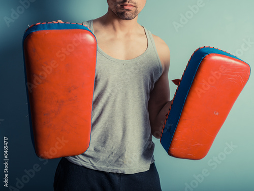 Athletic young man with martial arts pads