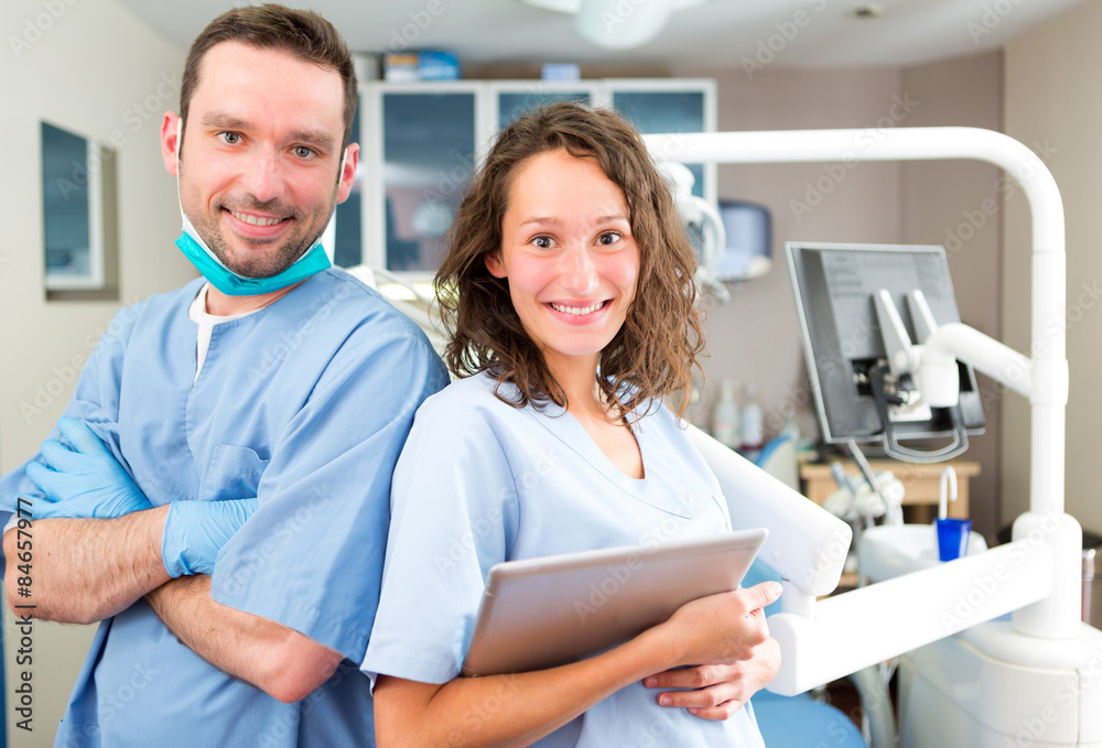 Obraz premium Portrait of a young attractive dentist and his assistant in his