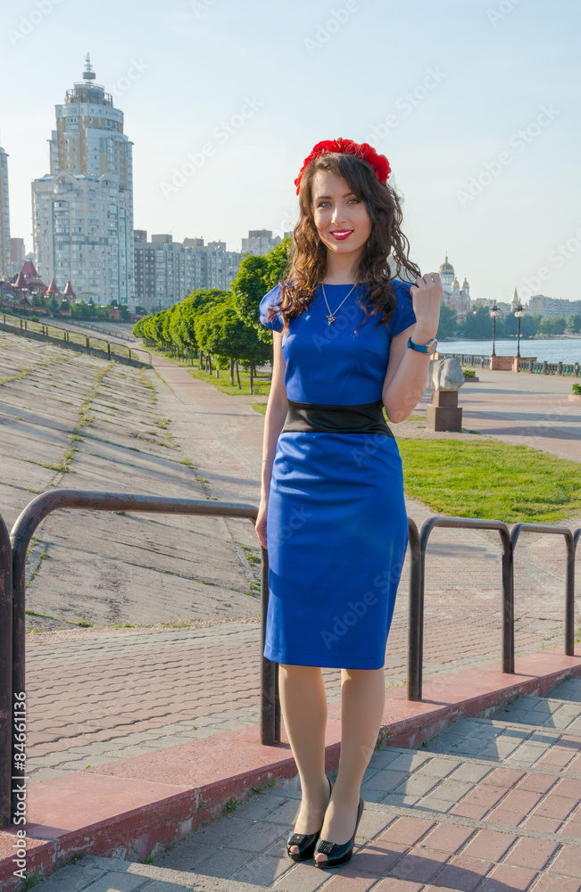 Fototapeta premium A young woman in a wreath in front of the cityscape.