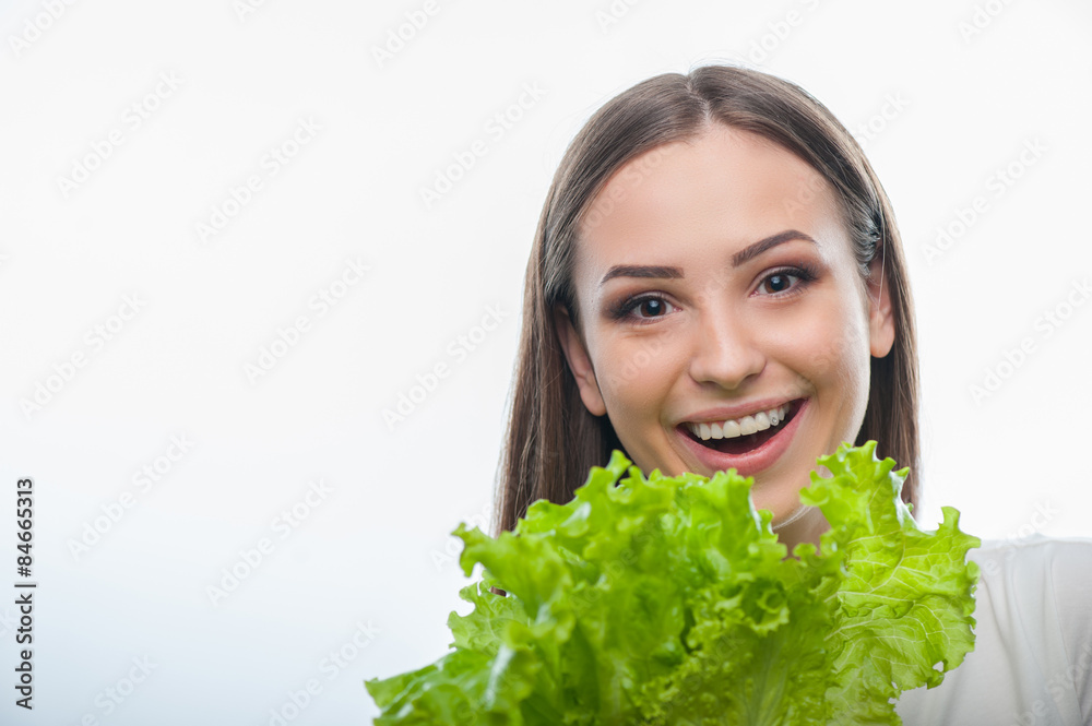 Pretty healthy woman is standing with green vegetable Pretty healthy woman is standing with green vegetable