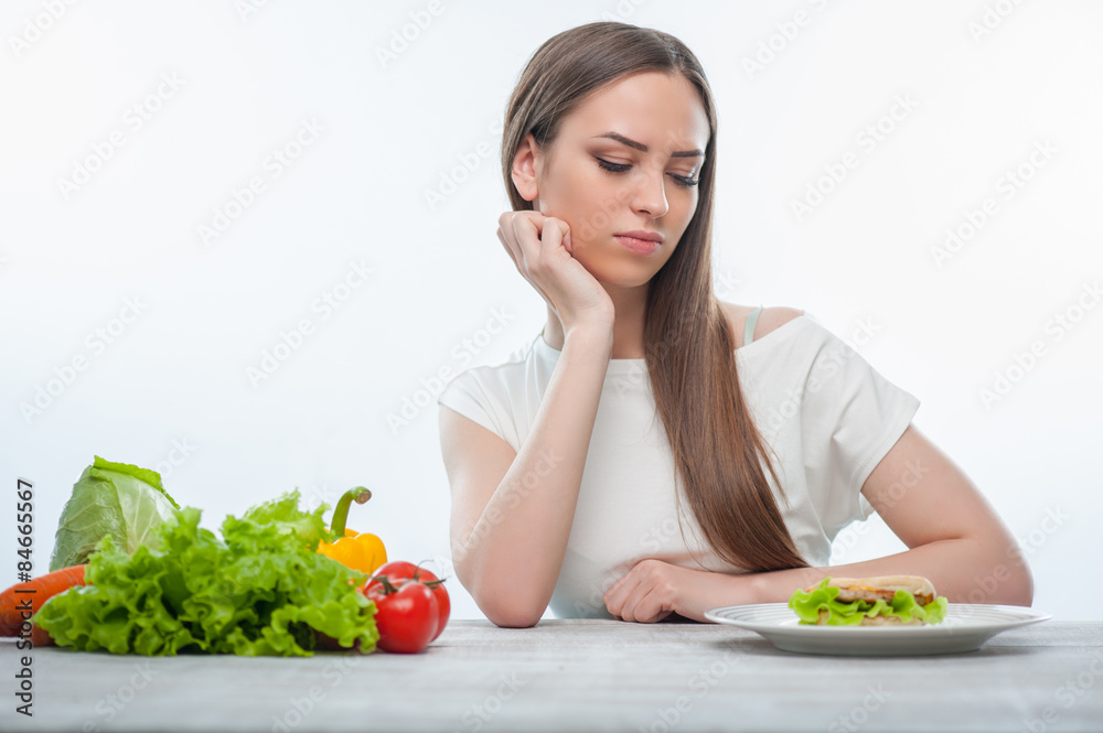 Woman is choosing between healthy and unhealthy food Woman is choosing between healthy and unhealthy food