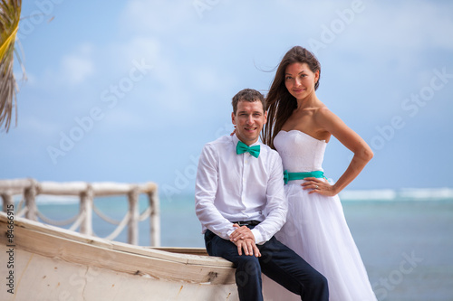Young loving couple wedding near the boat. © vladmilkov