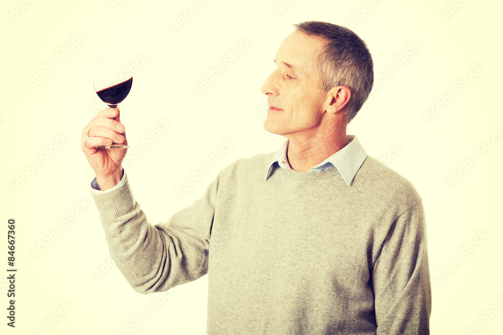 Mature man tasting red wine Mature man tasting red wine