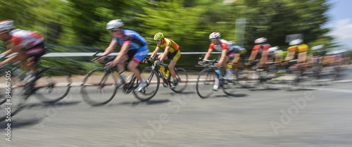 peloton of bicycle riders in a race in motion photo
