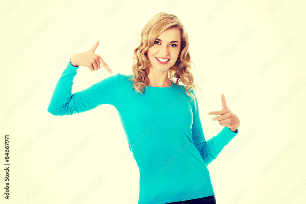 Smiling woman pointing at her shirt Smiling woman pointing at her shirt