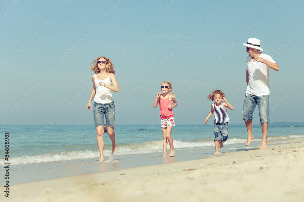 Happy family walking on the beach at the day time.
