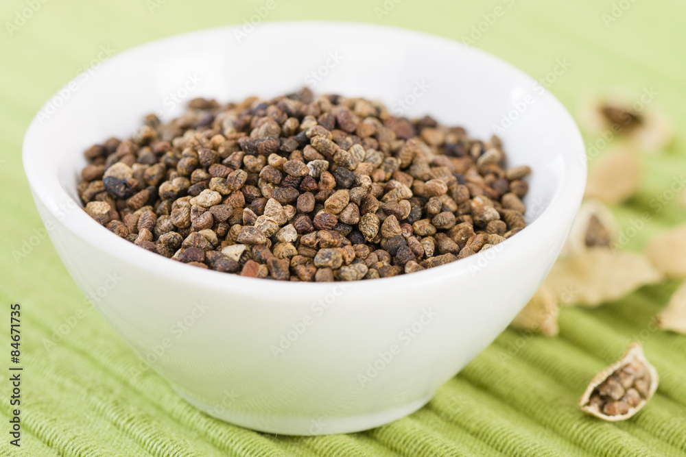 Cardamom Seeds - Bowl of cardamom seeds in a green background.
Cardamom Seeds - Bowl of cardamom seeds in a green background.