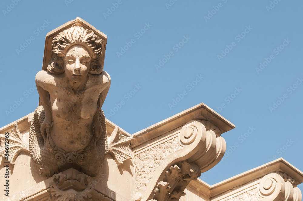 Ornamental sculpture of a mermaid on the roof of a Baroque palace in Lentini, Sicily