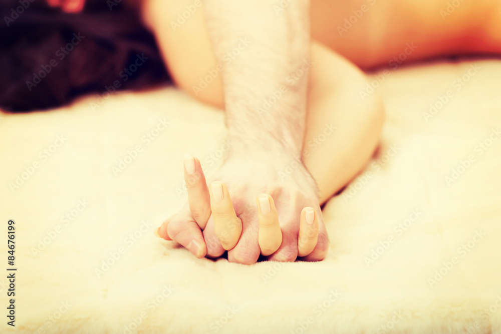 Hands of female and male lying on bed Hands of female and male lying on bed