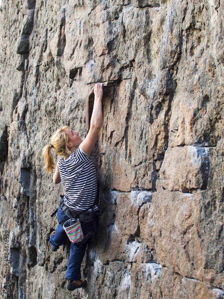 Young woman with rope climbs on the rock. Young woman with rope climbs on the rock.