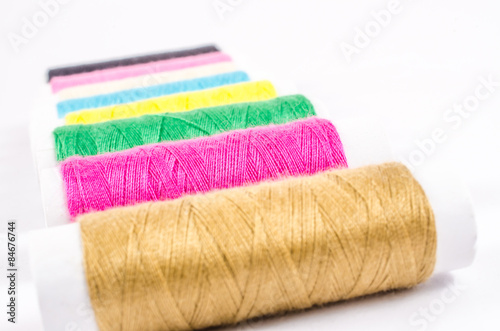 multicolor sewing threads on white background,