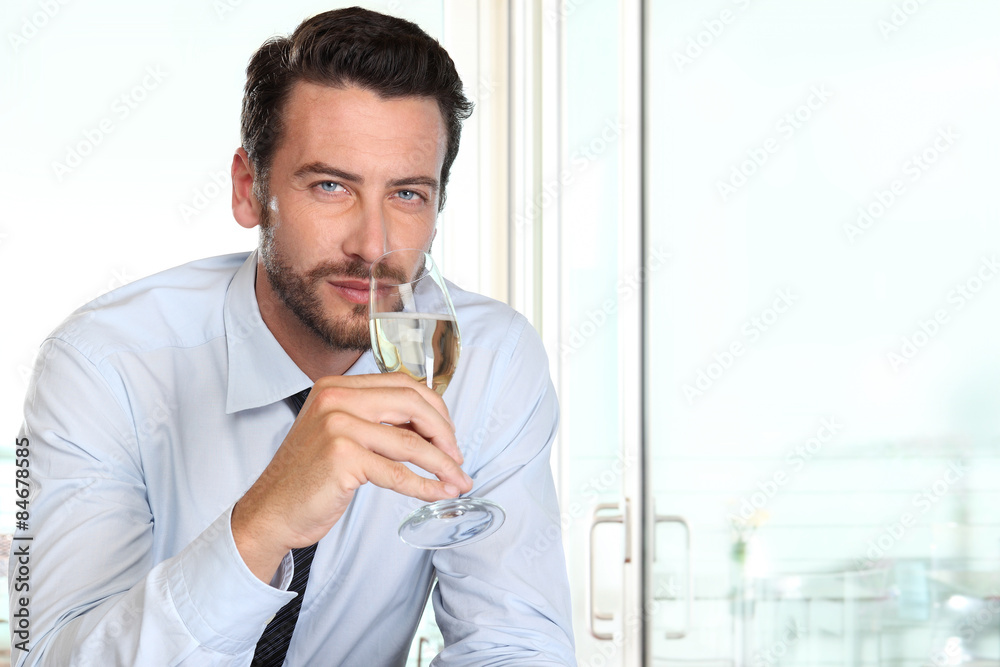 beautiful man drinking champagne with intriguing look and haught