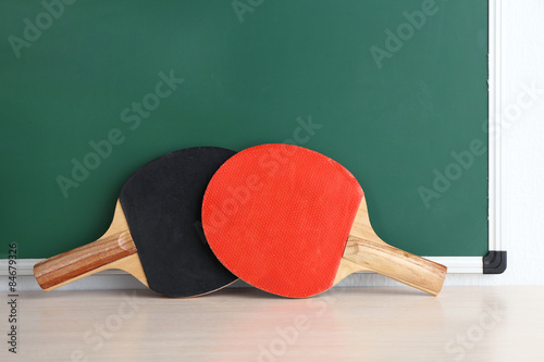 Table tennis rackets on blackboard background
