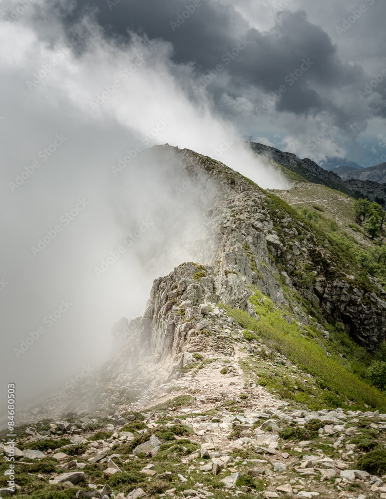 Clouds meet the top of a mountain ridge on GR20 in Corsica