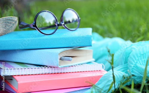 Books and glasses on grass close-up