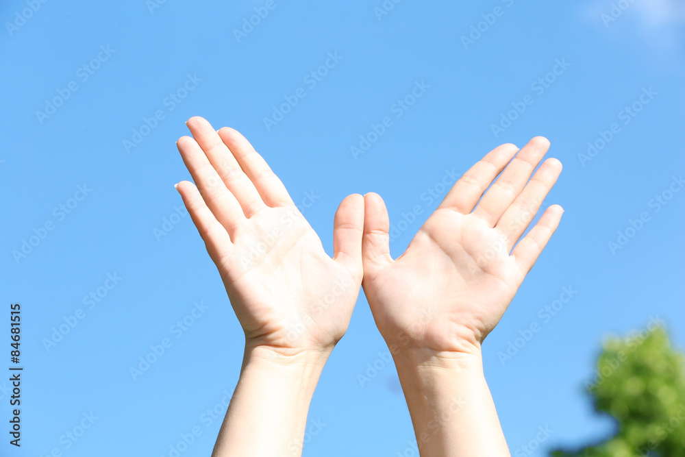 Female hands over blue sky background Female hands over blue sky background