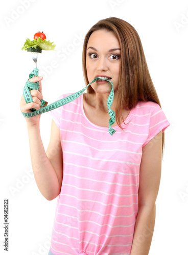 Healthy young woman with vegetables on fork and measuring tape isolated on white